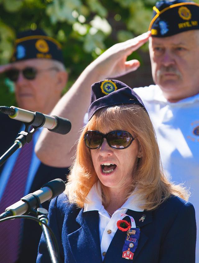 Rye Fire Police Patrol member Robin Latimer sings at the Memorial Day Ceremony. Photo by RFD FF Lester Millman 